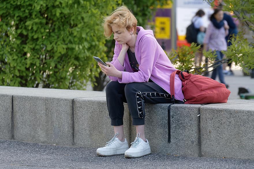 žena, sedící, park, venku, beton, chytrý telefon, telefon, hledá, městský, město, mobilní telefon