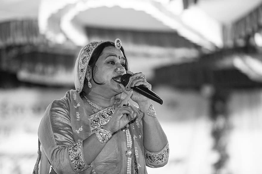 cantant, La cantant Asha Vaishnav, cantant indi, micròfon, actuació escènica, Quadres Escènics, obra de teatre, bhajan, cançó, Anil Sain Nagaur, Baras Baras Mahara Indar Raza