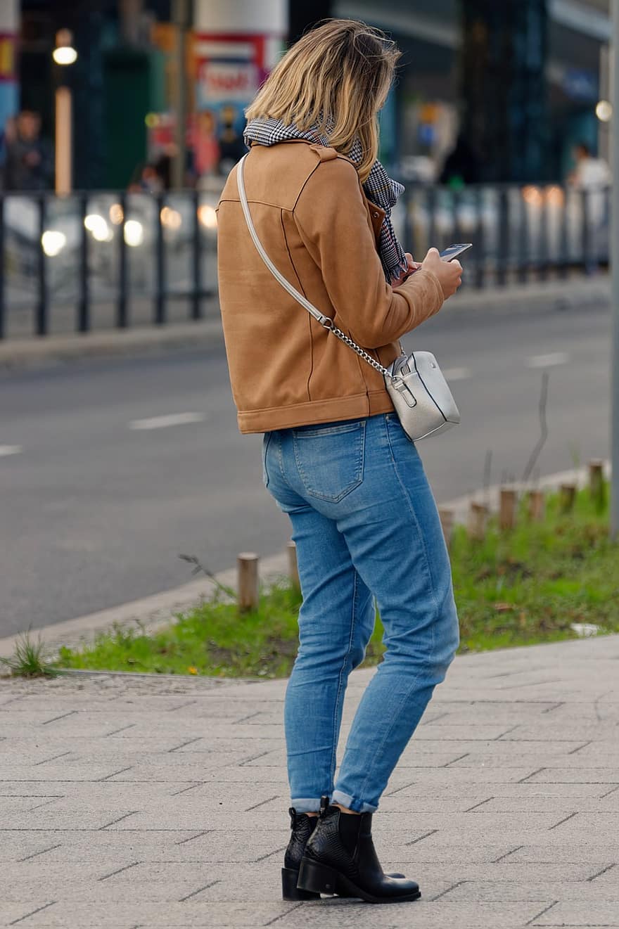 kvinna, väntar, gata, jeans, stövlar, jacka, utomhus