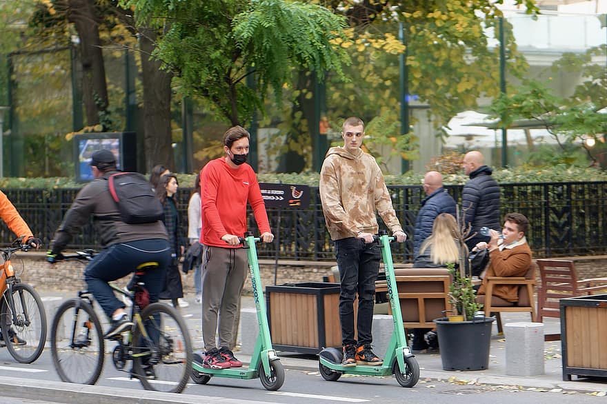 scooters elèctrics, gent, vianants, ciclistes, parc, carrer, carretera, ciutat, urbà, vida de ciutat