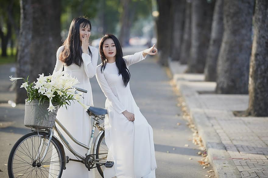 women, ao dai, bicycle, smiling, lifestyles, happiness, cheerful, two people, young adult, adult, togetherness