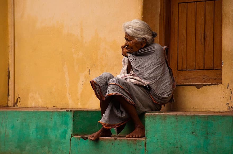 пожилая женщина, старая женщина, сидя на крыльце