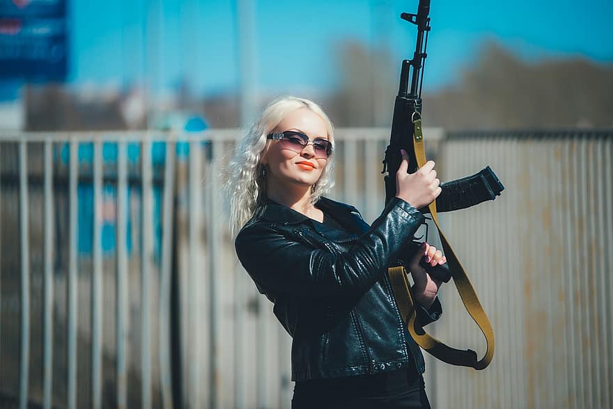 kul blondine, Jente med en pistol, rekkefølge, Kozhanka, skinnjakke, ponte, en trussel, fare, aggresjon, raseri, mørke briller