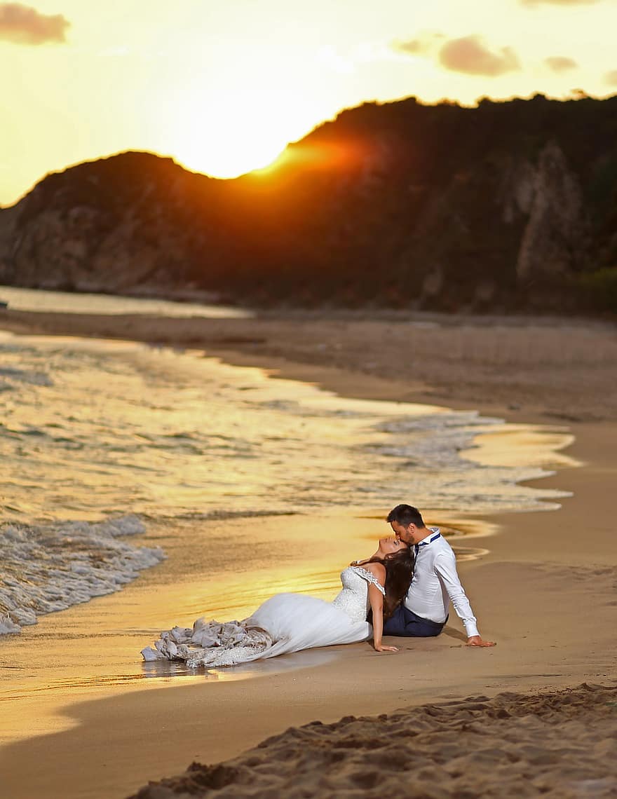 huwelijksfotografie, pas getrouwd, man en vrouw, bruid en bruidegom, strand, zonsondergang, zand, golven, strand bruiloft, trouwjurk, bruid