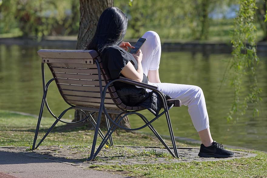 женщина, расслабляющий, скамейка, парк, деревья, смартфон, сидящий, на открытом воздухе, женщины, люди, образ жизни