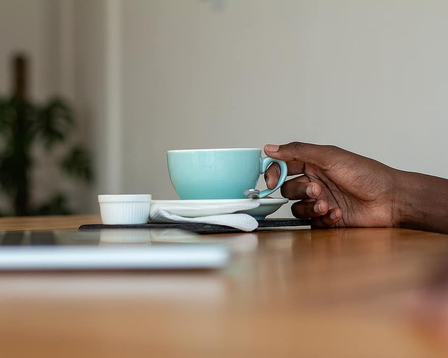 Koffie en handen, Koffie in een hand, Handen en koffie, koffie vasthouden, Koffiekopje in een hand, Koffie op een tafel, koffie, latte, cappuccino, drank, mok