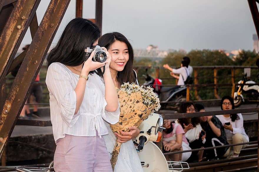 kobiety, młody, aparat fotograficzny, kwiaty, zachód słońca, bukiet, Żelazny Most, długi most Bien, portret, dziewczyna trzyma kwiaty, Hanoi