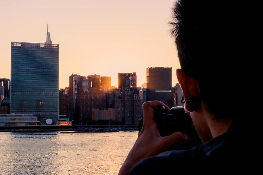 edifici, fiume, uomo, fotografo, New York, nyc, New York City, tramonto, i raggi del sole, luce del sole, acqua