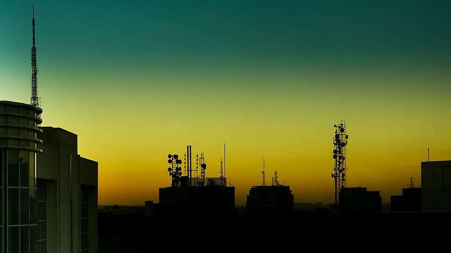 posta de sol, ciutat, antenes, silueta, edificis, gratacels, horitzó, cel, llum solar, centre de la ciutat, urbà
